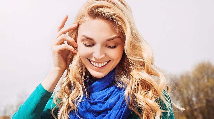 Lächelnde Frau mit wallendem blonden Haar